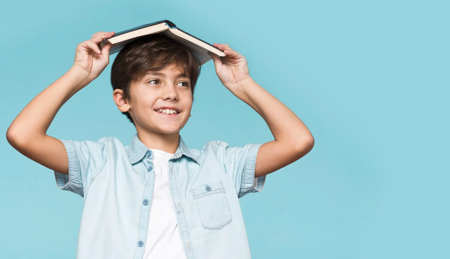 young-boy-holding-book-his-head-1 - Informacja o podręcznikach